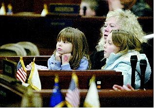 Michelle McQueary, 6, left, and Taylor Rampley, 9, sit with their mentor Laura Schueller on  Wednesday as part of a group from the Mentor Center who learned about the Assembly chambers at the Legislature.