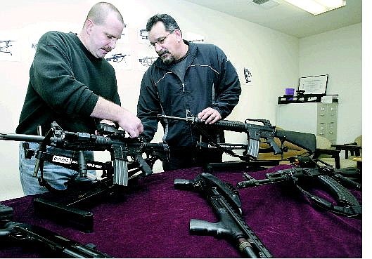Cathleen Allison/Nevada Appeal Mike Carlson, left, adjusts the sight on an AR-15 Commando Wednesday with business partner Russ Peterson. They run Tactical Customs, a Carson City gun-manufacturing business.