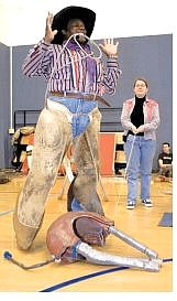 Cowboy Jim Brooks shows elementary schoolchildren how cowboys prepare to rope a calf during a demonstration in Elko on Monday.