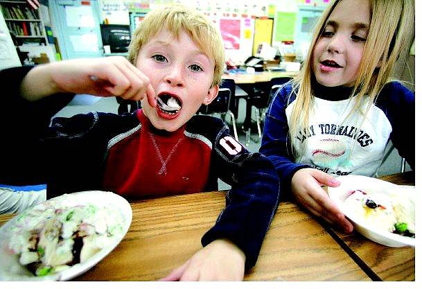BRAD HORN/Nevada Appeal Christopher Fulwider, 7, and Annah Howard, 6, enjoy ice cream in Mary Kay Kinne&#039;s first-grade class at Fritsch Elementary School on Friday. Students used fake bills and coins to purchase the sundaes as a way to learn money-counting skills.