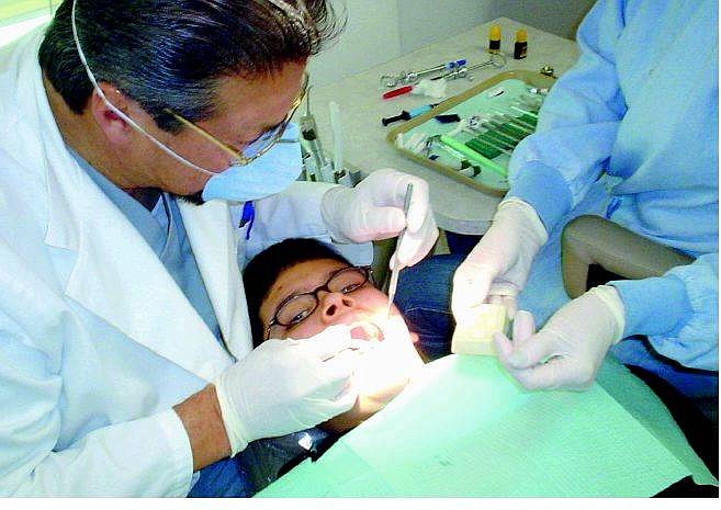 Josh Johnson/Appeal News Service        Luis Dominguez, 14, gets his teeth cleaned by Fallon dentist Dr. Tony Guillen  as part of Give Kids A Smile Day. Dr. George Henderson also offered free services for kids.