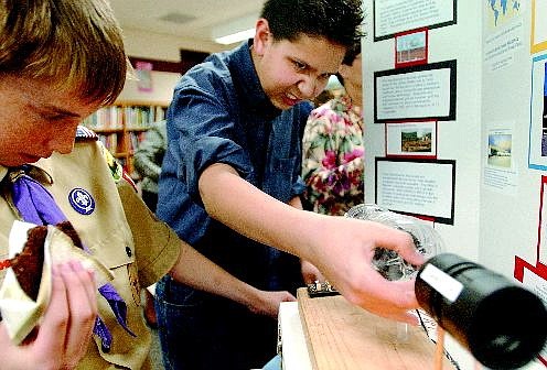 Rick Gunn/Nevada Appeal Carson Middle School science student Tyler Mireles, 13, puts on his best evil scientist look while tinkering with his Green Project entitled &quot;Flashco.&quot; Studying the project next to him is Tanner Anderson, 12.