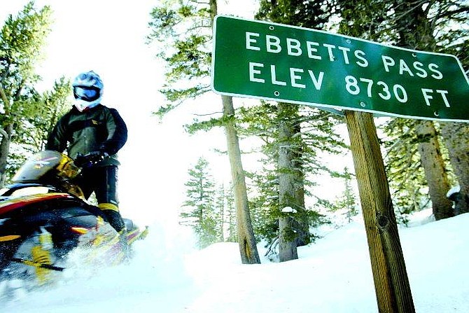 Robert Durell/Los Angeles Times Alpine County Deputy Sheriff Rick Stephens, zooms by the summit of Ebbetts Pass on Highway 4, Feb. 1. Every winter snow closes the pass forcing residents to make a three-hour drive between Markleeville and Bear Valley or make an hour snowmobile drive.
