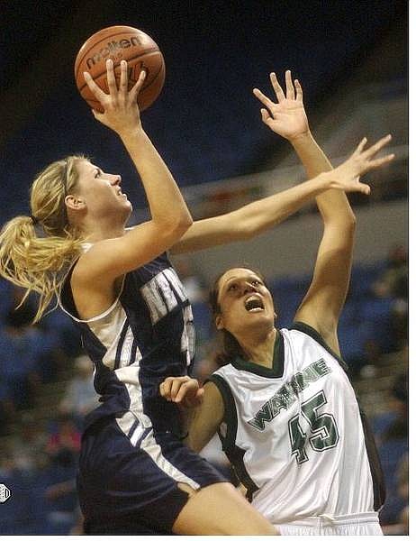 Rick Gunn/Nevada Appeal Andrea Sitton of the Wolf Pack drives the ball against Amber Lee of Hawaii&#039;s Rainbow Wahine Tuesday at Lawlor during the WAC tournament.