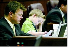 Cathleen Allison/Nevada Appeal Assemblyman Chad Christensen, R-Las Vegas, and his son Cole, 8, work on the Assembly floor Monday morning.