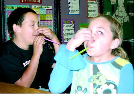 Maggie O&#039;Neill/Nevada Appeal Freddie Ramirez, 9, and Sienna Collins, 10, suck on straws for one minute to simulate emphysema. The fourth-grade Seeliger students received a presentation from Carson High School Resist students on Monday about the harmful effects of cigarettes.