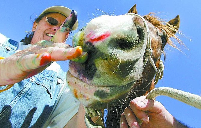 Brad Horn/Nevada Appeal Kathy Graves puts paint on her 2-year-old adopted wild mustang&#039;s nose at Betty and Bob Retzer&#039;s Stagecoach ranch on March 12. The Retzer&#039;s run a horse mentoring business using the Least Resistance Training Concepts and use this exercise to help their clients bond with their animals.