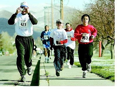 Greg Lehman, left, runs with his son Caden, 8, of Carson City, during the Jester Jog on Saturday. The eighth annual jog raises money for the Children&#039;s Museum of Northern Nevada.  BRAD HORN/Nevada Appeal