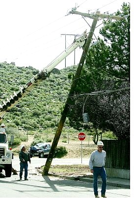 BRAD HORN/Nevada Appeal Utility workers repair a power pole at the corner of Roop Street and Winnie Lane after an accident involving a truck on Monday morning.