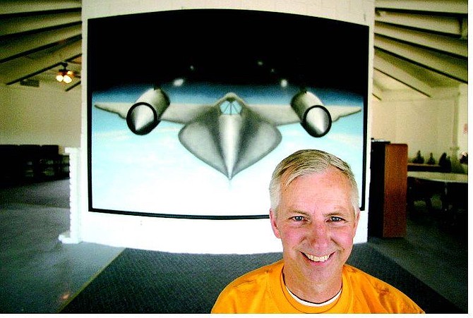 Elroy &quot;Buz&quot; Devoll poses in front of a painting of an SR-71 that he and a friend, Adam Baker, airbrushed for his cafe at the Carson City Airport. BRAD HORN/Nevada Appeal