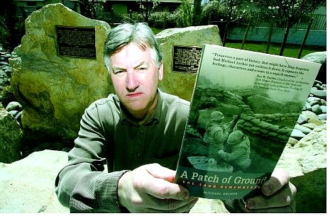 BRAD HORN/Nevada Appeal Michael Archer holds his book, &#039;A Patch of Ground,&#039; at the Vietnam Memorial at Mills Park on  Friday.