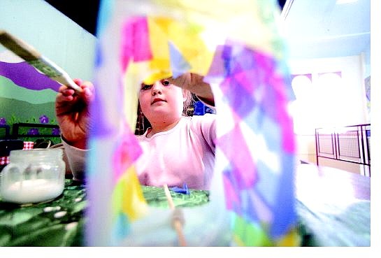 Carly Sauvageau, 7, of Tonopah puts colored pieces of paper on her bird feeder while at the Children&#039;s Museum of Northern Nevada during its Earth Day celebration Saturday.    BRAD HORN/ Nevada Appeal