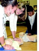 Laura Herrea, 13, left, Brooke Menning, 13, and Alfredo Morales, 12,  practice CPR Tuesday during PE class at Incline Middle School.   Wednesday, Menning put her emergency lessons to practice when a mini van drove off a bluff near Sand Harbor. ABOVE:  Emerald Bay Towing prepares to pull the van up Wednesday afternoon.