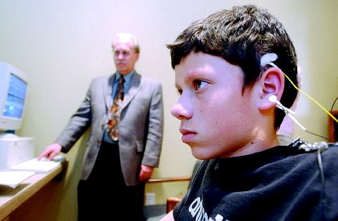 Rick Gunn/Nevada Appeal Mark Neddenriep, 14, sits before a computer monitor that provides feedback to his brain. The wires attached to his head measure brainwaves, which are monitored by a neurotherapy doctor, like Jerry Cinani, who stands behind.