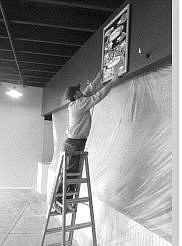 Tom Blaisdell, co-owner of the Pizza Factory in one of the new buildings at the Long&#039;s Shopping Center on Highway 50 East and Airport Road, hangs a pizza menu sign on the business under construction.   Rick Gunn Nevada Appeal