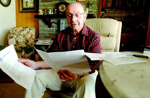 Rick Gunn/Nevada Appeal Retired State worker John Biale looks through his mail Tuesday at his home in Carson City. Biale recently received a notice informing him that his monthly public employees benefit program insurance pay went from $78.46 to $478.72.