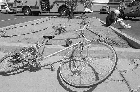 Rick Gunn/Nevada Appeal The driver of a vehicle that struck a bicyclist fills out a report near the Grocery Outlet Tuesday afternoon. The bicyclist was transported by ambulance to Carson-Tahoe  Hospital.