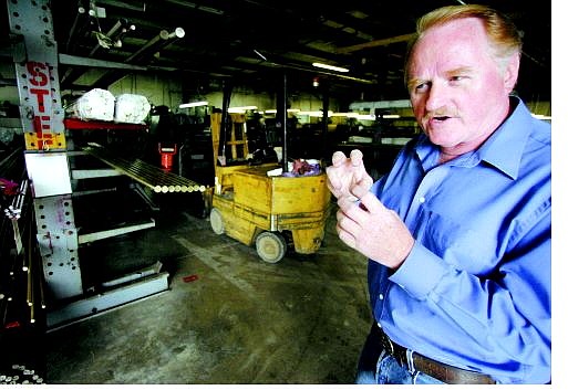 Gerd Poppinga, owner of Vineburg Machining Inc. in Mound House, explains what happens to brass rods when they are sent through his machine.   BRAD HORN/Nevada Appeal