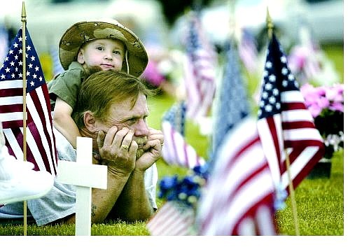 Cathleen Allison/Nevada Appeal Mike Garrett and his son Mike Garrett Jr., 2, attended the Memorial Day ceremony at Lone Mountain Cemetery Monday afternoon. They sat with family members at the gravesite of Garrett&#039;s father, Army veteran Thomas Garrett.