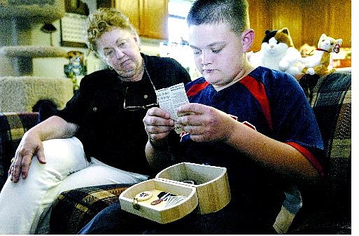 Kyle Matsko, 13, sorts through a memory box he made for his grandfather, Donald Revelle, with his grandmother Nellie Revelle at her Dayton home Wednesday. They received hospice care during her husband&#039;s illness.    Cathleen Allison Nevada Appeal