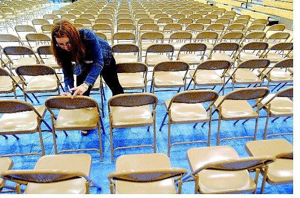 Rick Gunn/Nevada Appeal Silver Stage High student Stephannie Worden tapes tags on the reserved seats in preparation for the graduation ceremony Thursday evening in Silver Springs.