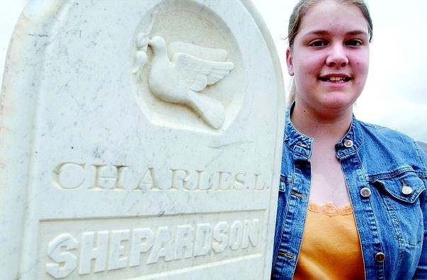 Rick Gunn/Nevada Appeal Dayton High student Michelle Richardson kneels next to the headstone of Charles L. Shepardson, who died Sept. 17, 1874. Richardson wrote about the life of Shepardson in her local-history research paper.