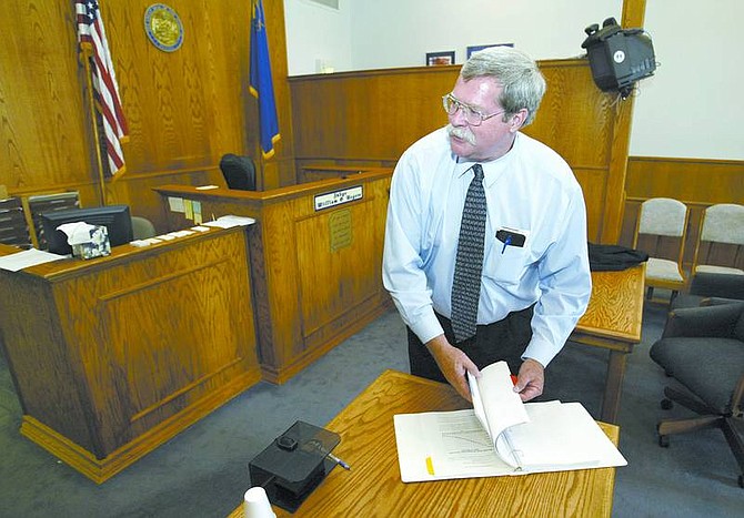 Cathleen Allison/Nevada Appeal Dayton Justice Court Judge Bill Rogers looks at a recent report on the Lyon County Corrections Master Plan in the Dayton courtroom Monday afternoon. Rogers says the rapid growth in the area is overtaxing the court system.