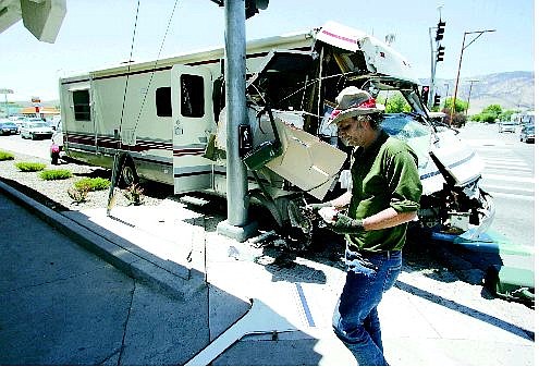 BRAD HORN/Nevada Appeal Alan Fellows, of Sacramento, walks by his 34-foot Pinnacle RV after he crashed, pinning his vehicle between a power pole and a stop light at the corner of Winnie Lane and Carson Street on Friday afternoon. The accident caused long traffic delays.