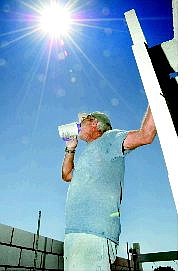 Nevada Appeal news service Richard Gilder, of Fallon, takes a break from laying cinder block in 100-plus degree weather to quench his thirst. Gilder has been drinking 2-3 gallons of water per day during the heat wave.