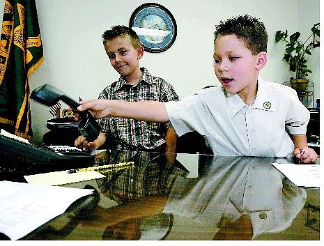 Chad Lundquist/Nevada Appeal Ernrique Sanchez, 8, of Carson City makes executive decisions as he learns about what it takes to be sheriff for a day. His brother Kaleb VanMeter, 7, left, helps with those issues as the official undersheriff.