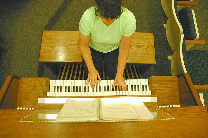 Kevin Clifford/Nevada Appeal Ward organist Angela McClelland of Dayton attempts to tune the Church of Jesus Christ of Latter-day Saint&#039;s organ Tuesday in preparation of the first meeting Aug. 14. McClelland has been organist for a year.