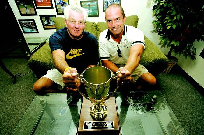 BRAD HORN/Nevada Appeal Carson High School athletic director Ron McNutt, left, and his Douglas High School counterpart, Jeff Evans, pose with the SIerra Nevada Cup at Carson High School on Wednesday.