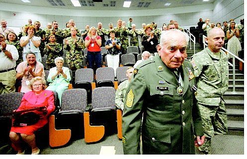 BRAD HORN/Nevada Appeal Command Sgt. Maj. (Ret.) Ensio Tosolini walks to the podium while his wife, Claudette, left, in pink, watches on Friday at the Office of the Adjutant General.