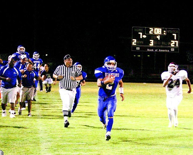 BRAD HORN/Nevada Appeal Carson quarterback Chris McBroom takes the ball down the sideline for a (60 yard) gain while the Carson sideline erupts in the 4th quarter in Carson on Friday.