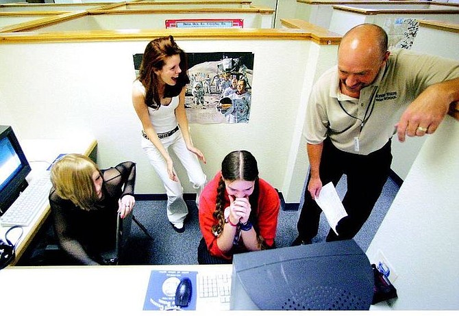 BRAD HORN/Nevada Appeal Nicole Halabuk, 16, from left, Kylie Antti, 16, Rachel Kennedy, 16, and teacher David Papke laugh after reading an introduction written by Kennedy for an English class at Silver State Charter School on Thursday. One of the features of the school is small cubicles where students can work without distractions. Kennedy and Halabuk said this has enhanced their ability to study at school.