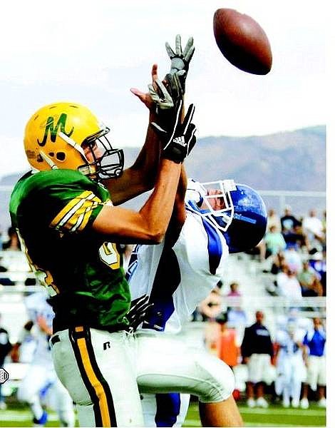 Manogue Miner wide receiver Patrick O&#039;Neil, in green and yellow, fights for the ball with Carson Senator defensive back Ryan Jesse during the second half of their game at Manogue High School in Reno, Nev., on Saturday, Sept. 10, 2005. After falling behind 12-0 to the visiting Senators, the Miners came back to win 34-25. AP Photo Brad Horn/Nevada Appeal