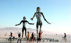 Sam Bauman/Nevada Appeal Burning Man guests view and photograph two towering statues on the Black Rock playa that were typical of the more than 200 original works of art scattered about the playa, outside Black Rock City. The distant Calico Mountains are obscured by blowing clay dust.