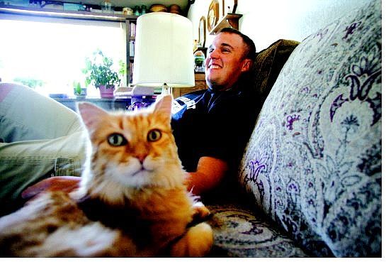 Derek Best, an E4 Specialist with the 403rd Cargo Transfer Company, plays with his cat Max at his parent&#039;s Carson City home on Wednesday.   BRAD HORN Nevada Appeal