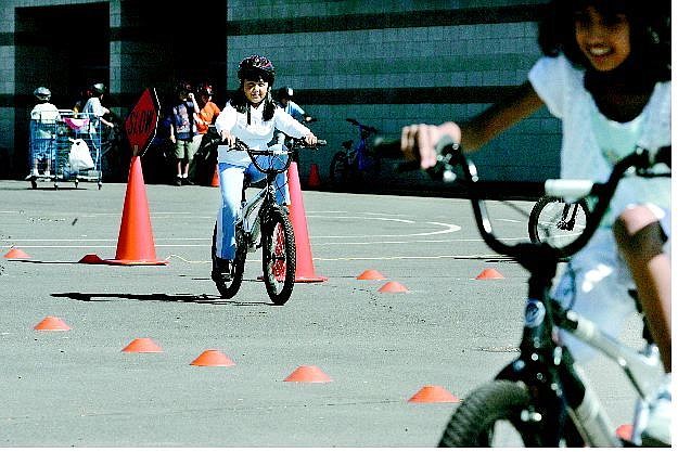 Cathleen Allison/Nevada Appeal Fremont Elementary School fifth-graders Arlette Mariscal, left, and Saania Ahmad ride the bike-safety course at the school Thursday.  P.E. teacher Denis Coyne teaches students how to use hand signals and navigate obstacles.