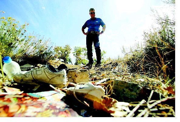 BRAD HORN/Nevada Appeal Ron Bowman, co-chairman of the Carson City Kiwanis Club, stands in the remains of a trailer that was torched near the Carson River on Thursday. The Kiwanis will hold its 20th annual river cleanup Oct. 8.