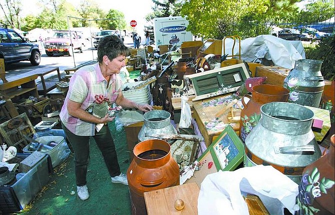 Cathleen Allison/Nevada Appeal  Diane Cobasky, of Prescott, Ariz., sorts through her wooden crafts after the wind destroyed her booth at the Candy Dance on Friday afternoon. Cobasky, who has been a vendor at the Genoa show for 14 years, had almost finished more than 12 hours of work to set up her booth when the wind tore 30 feet of canopy away and scattered her crafts. A number of other vendors in the area also battled the wind and suffered minor damage as they prepared for this weekend&#039;s event.