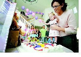 BRAD HORN/Nevada Appeal Alison Roylance holds her daughter Raychel over her birthday cake celebrating her first birthday while friends, family and Washoe Medical Center&#039;s neonatal intensive care unit nurses watch on Saturday at Roxy Brewer&#039;s Carson City home. Raychel was born at 27 weeks, weighing 1 pound 10 ounces.