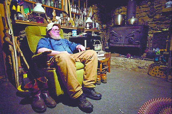 Rusty Nesbitt sits in his turn-of-the century Appalachian cabin.