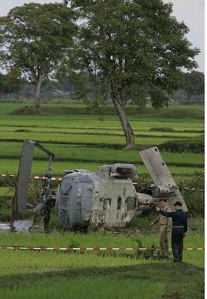 Associated Press Two U.S. servicemen search for pieces of debris from a U.S. Navy Seahawk helicopter which crashed in a rice paddy less then a kilometer away from Banda Aceh&#039;s airport this morning.