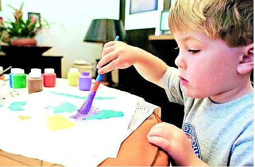 Noah Lyle, 3, paints a fish that will be sold on eBay. Noah has received offers to appear on local and national talk shows.  Julie Sullivan/  Appeal News Service