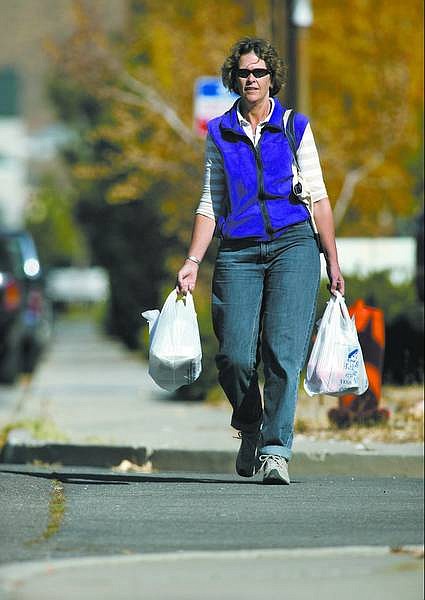 Cathleen Allison/Nevada Appeal Anne Macquarie walks home from the grocery store Friday morning. Macquarie vowed to walk, carpool, use public transportation and ride her bike in October to see how pedestrian-friendly Carson City is.