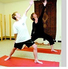 Shannon Litz/Appeal News Service Yoga instructor Jill Mustacchio does a yoga position with her son Jaden, 10, at O2 Wellness Studio. Mustacchio will be teaching a yoga for cancer patients class as well as a yoga for kids class.