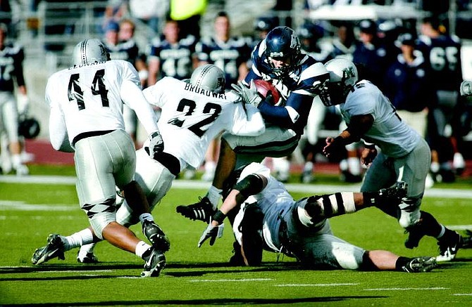 Nevada receiver Jack Darlington gets tackled by Hawaii defenders, from left, Adam Leonard (44), Lamar Broadway (22), Melila Purcell (98), and Lono Manners (15) in the second half of Saturday&#039;s game, Nov. 5, 2005 in Reno, Nev. Nevada won 38-28. (AP Photo/Cathleen Allison)