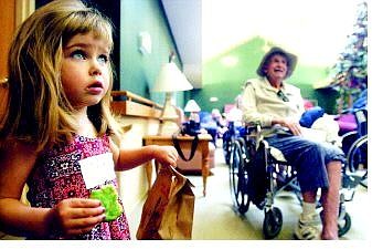 BRAD HORN/Nevada Appeal Zoe Tetz, 3, of Carson City, helps hand out gifts to the veterans at Evergreen Health Care during a Veterans Day celebration Friday.