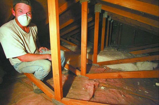 BRAD HORN/Nevada Appeal Todd McPhail installs thicker insulation material into the attic of a north Carson City home. The insulation will help keep the home warm in the winter and cool in the summer.